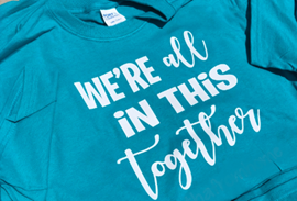 A blue T-shirt that says: We're all in this together A blue T-shirt that says: We're all in this together